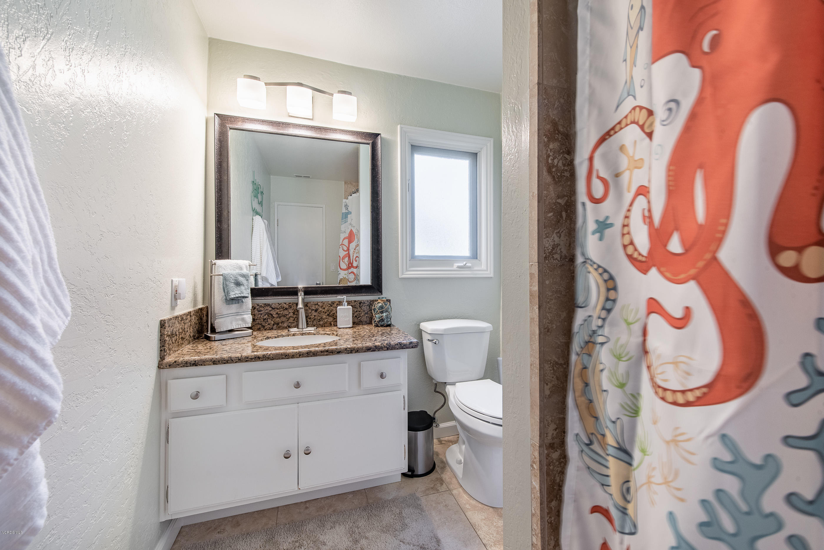 1242 Rambling Road Simi Valley, CA 93065 - Photo 35 of 81 a bathroom with a toilet sink vanity and mirror