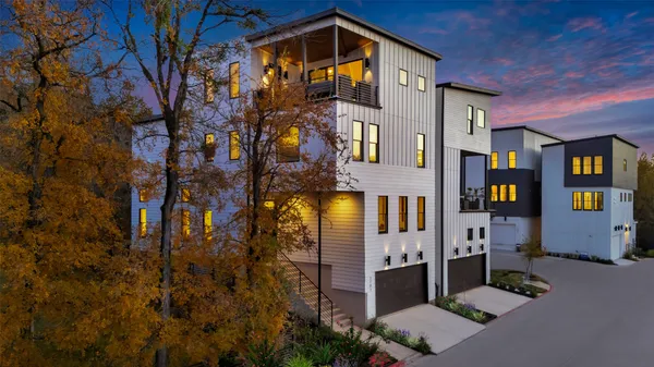 a front view of a multi story residential apartment building with yard and retail shops