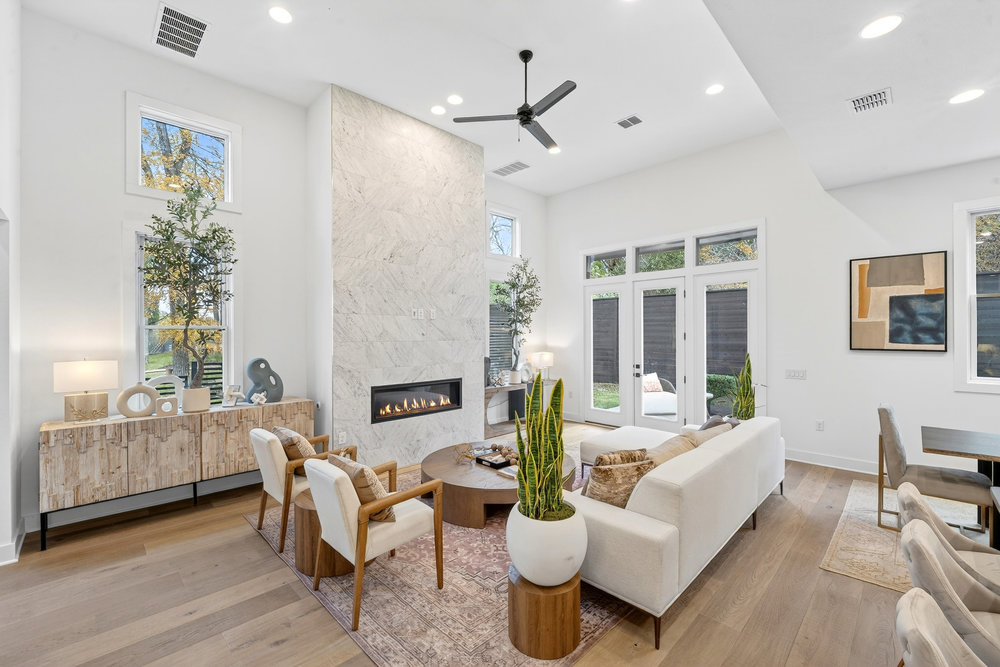 2707 Salek View Austin, TX 78741 - Photo 14 of 37 Living room featuring a high end fireplace, hardwood / wood-style flooring, recessed lighting, a ceiling fan, and a towering ceiling