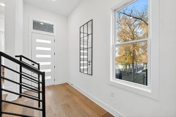a view of front door with wooden floor and a window
