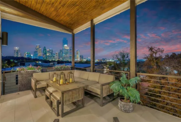 a roof deck with couches and potted plants