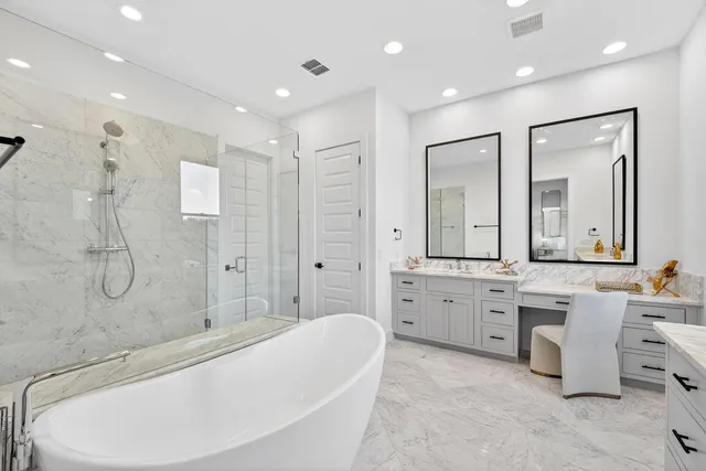 a large spacious bathroom with a tub sink shower and mirror