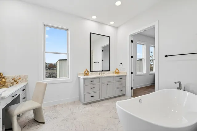 a bathroom with a tub sink and mirror