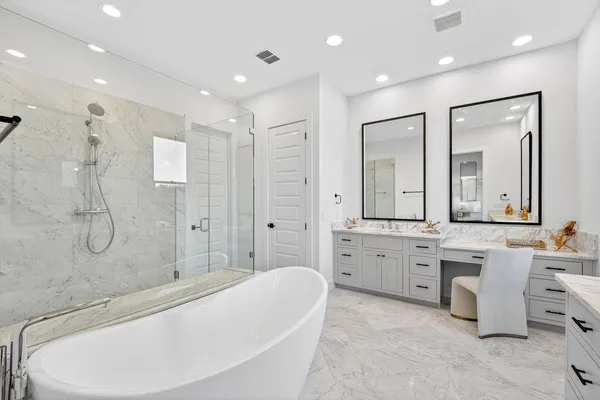 a large spacious bathroom with a tub sink shower and mirror