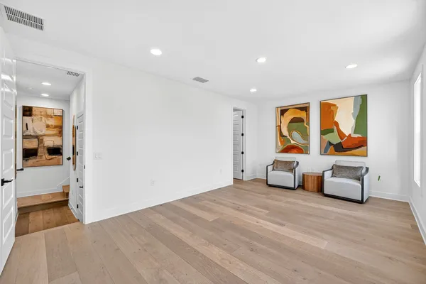 a view of an empty room with window and wooden floor