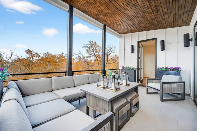 a living room with furniture large window and wooden floor