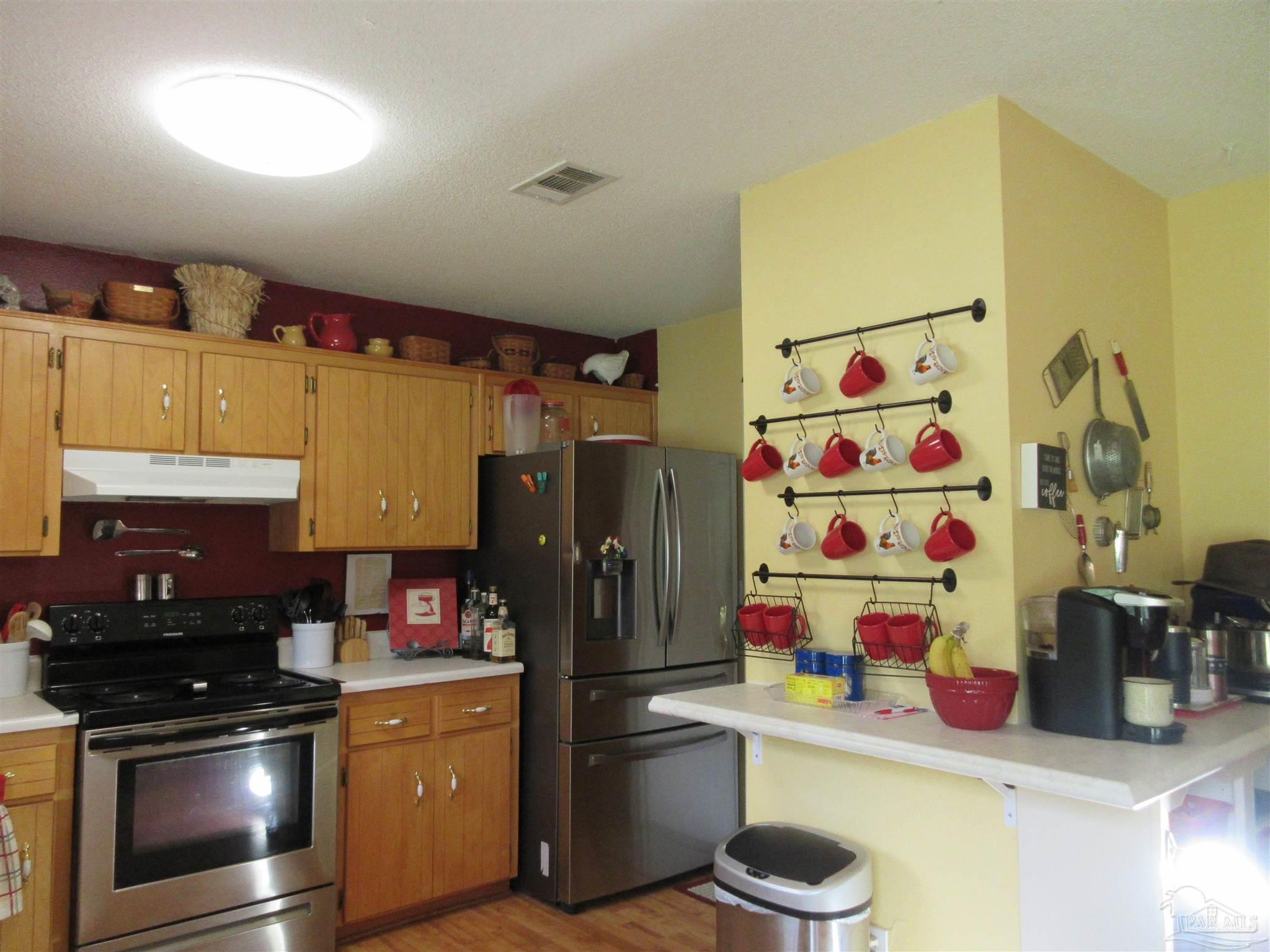 4523 Struth Lane Pace, FL 32571 - Photo 18 of 49 a kitchen with a refrigerator and a stove top oven