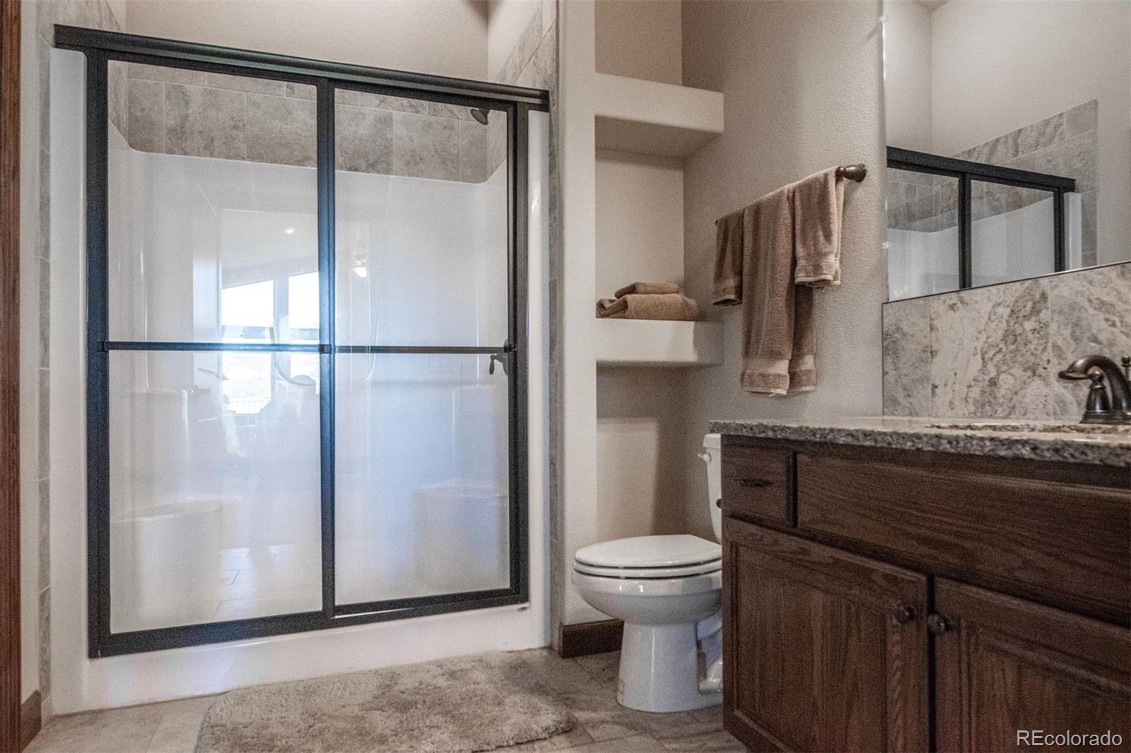 Undisclosed Address Paradox, CO 81429 - Photo 18 of 50 a bathroom with a granite countertop sink toilet and shower