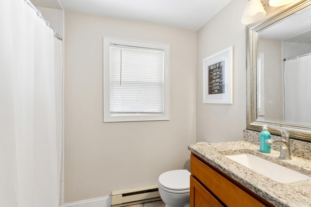 299 Asbury Street Hamilton, MA 01982 - Photo 11 of 37 a bathroom with a granite countertop toilet sink and mirror