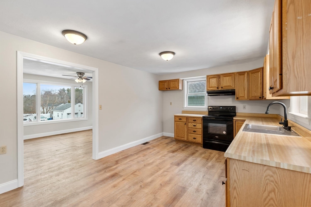 299 Asbury Street Hamilton, MA 01982 - Photo 19 of 37 a kitchen with granite countertop a stove top oven sink and cabinets