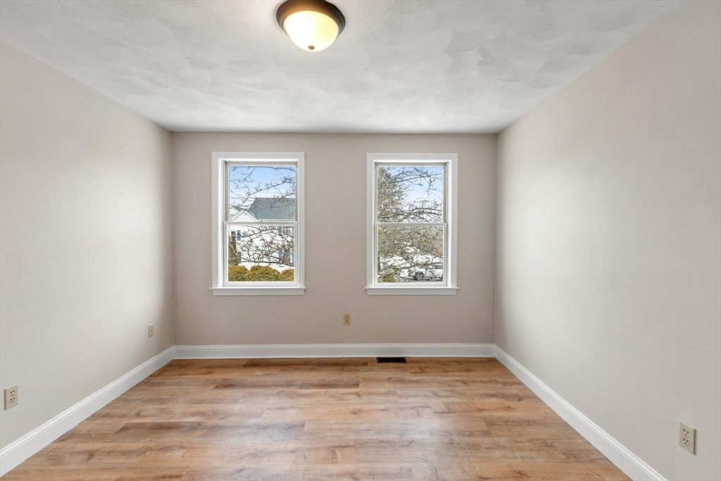 299 Asbury Street Hamilton, MA 01982 - Photo 28 of 37 an empty room with wooden floor and windows