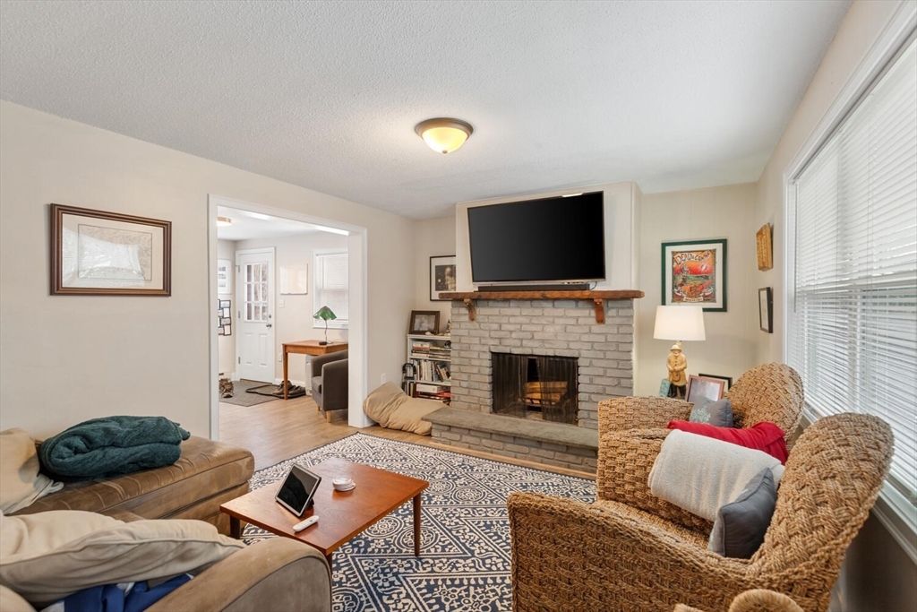 299 Asbury Street Hamilton, MA 01982 - Photo 8 of 37 a living room with furniture and a fireplace