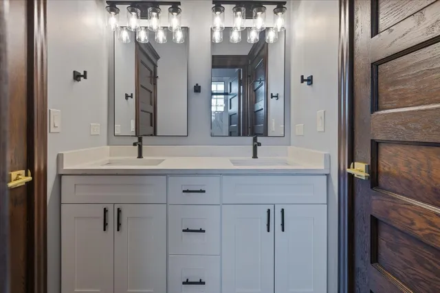 a bathroom with a double vanity sink and a mirror