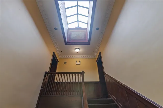 a view of staircase with railing and white walls