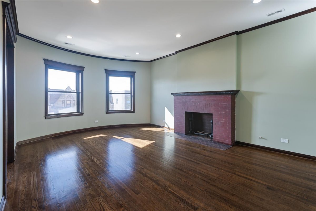 442-444 East 48th Street, Unit 2E Chicago, IL 60615 - Photo 10 of 28 an empty room with wooden floor fireplace and windows