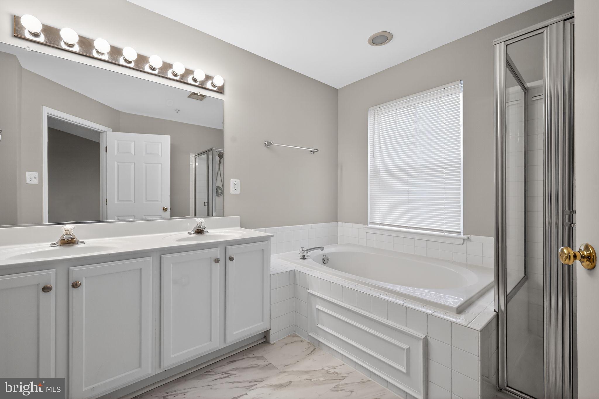 18707 Little Star Lane Germantown, MD 20874 - Photo 22 of 30 a bathroom with a tub a sink and mirror