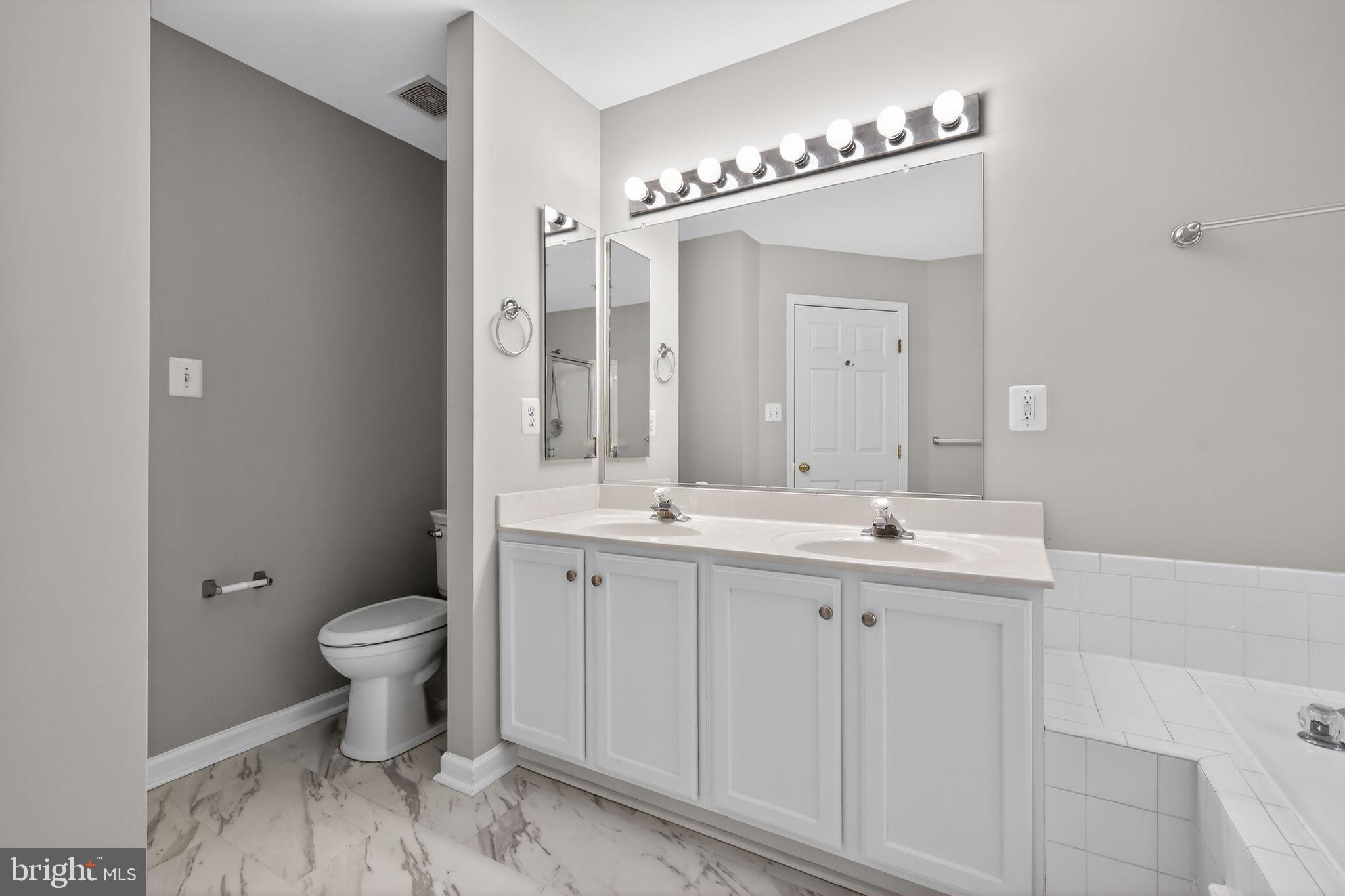 18707 Little Star Lane Germantown, MD 20874 - Photo 26 of 30 a bathroom with a sink toilet a mirror and shower