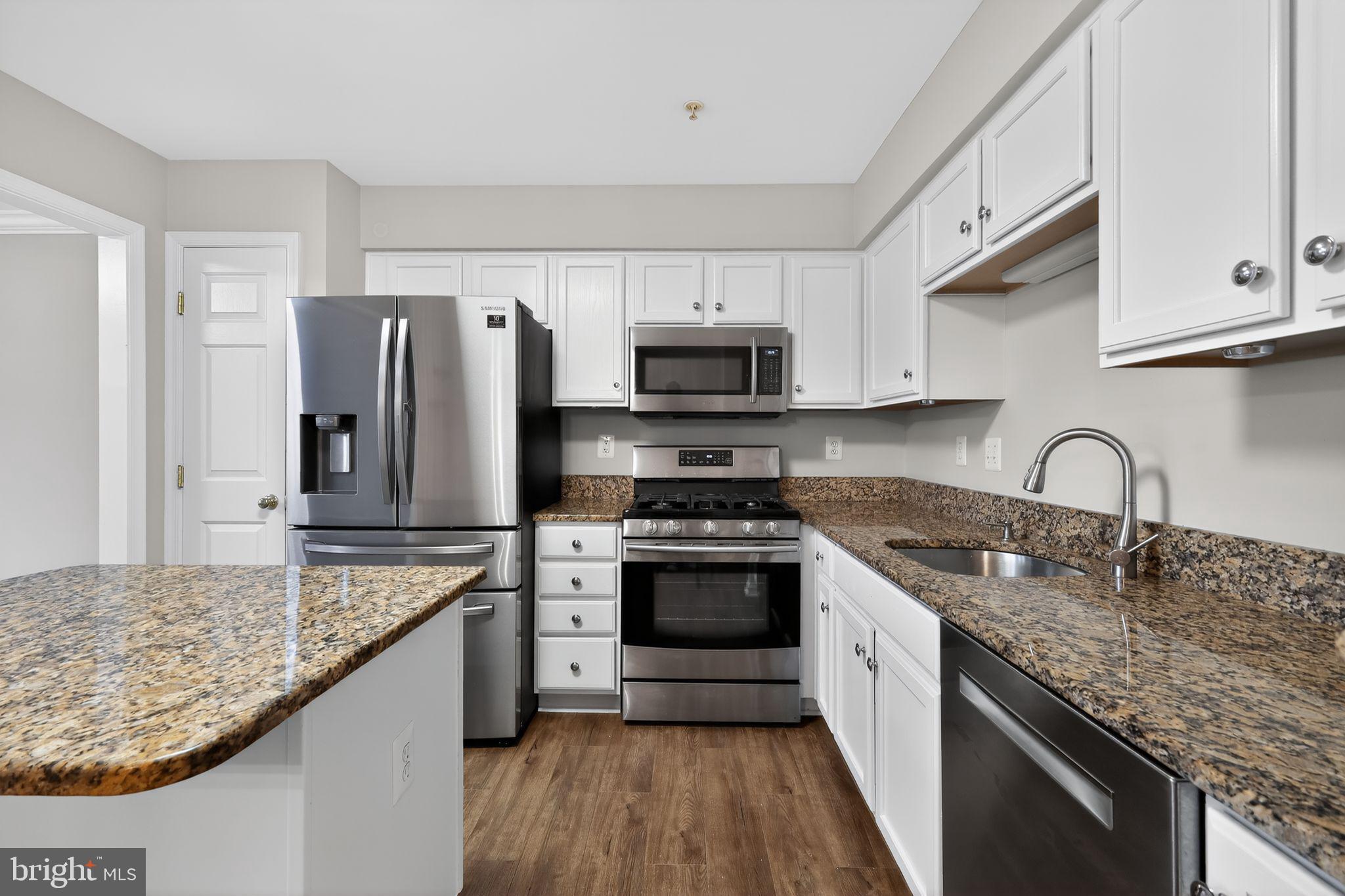 18707 Little Star Lane Germantown, MD 20874 - Photo 4 of 30 a kitchen with stainless steel appliances granite countertop a sink stove microwave and refrigerator