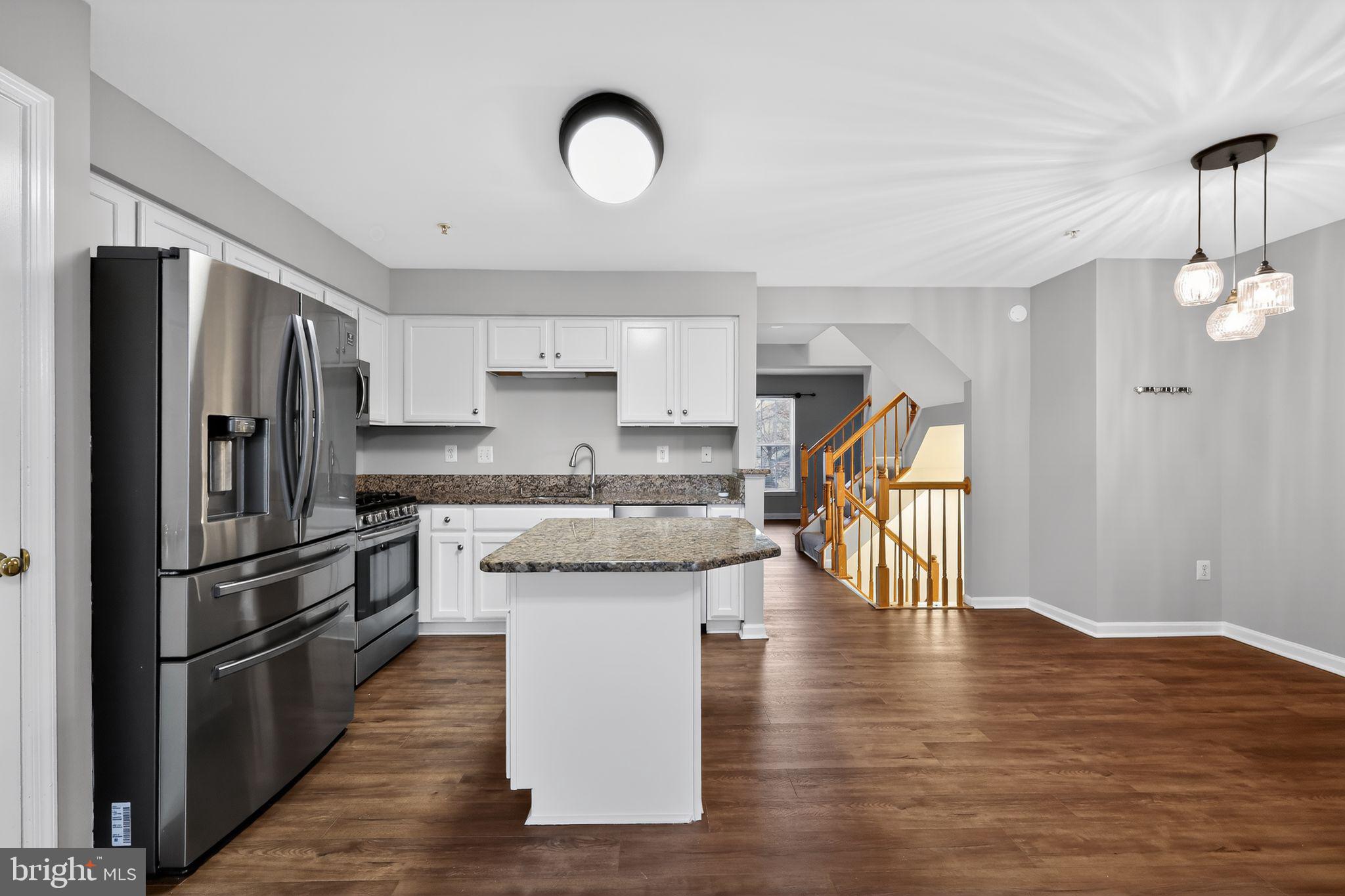 18707 Little Star Lane Germantown, MD 20874 - Photo 6 of 30 a kitchen with stainless steel appliances granite countertop a refrigerator a stove and a wooden floors