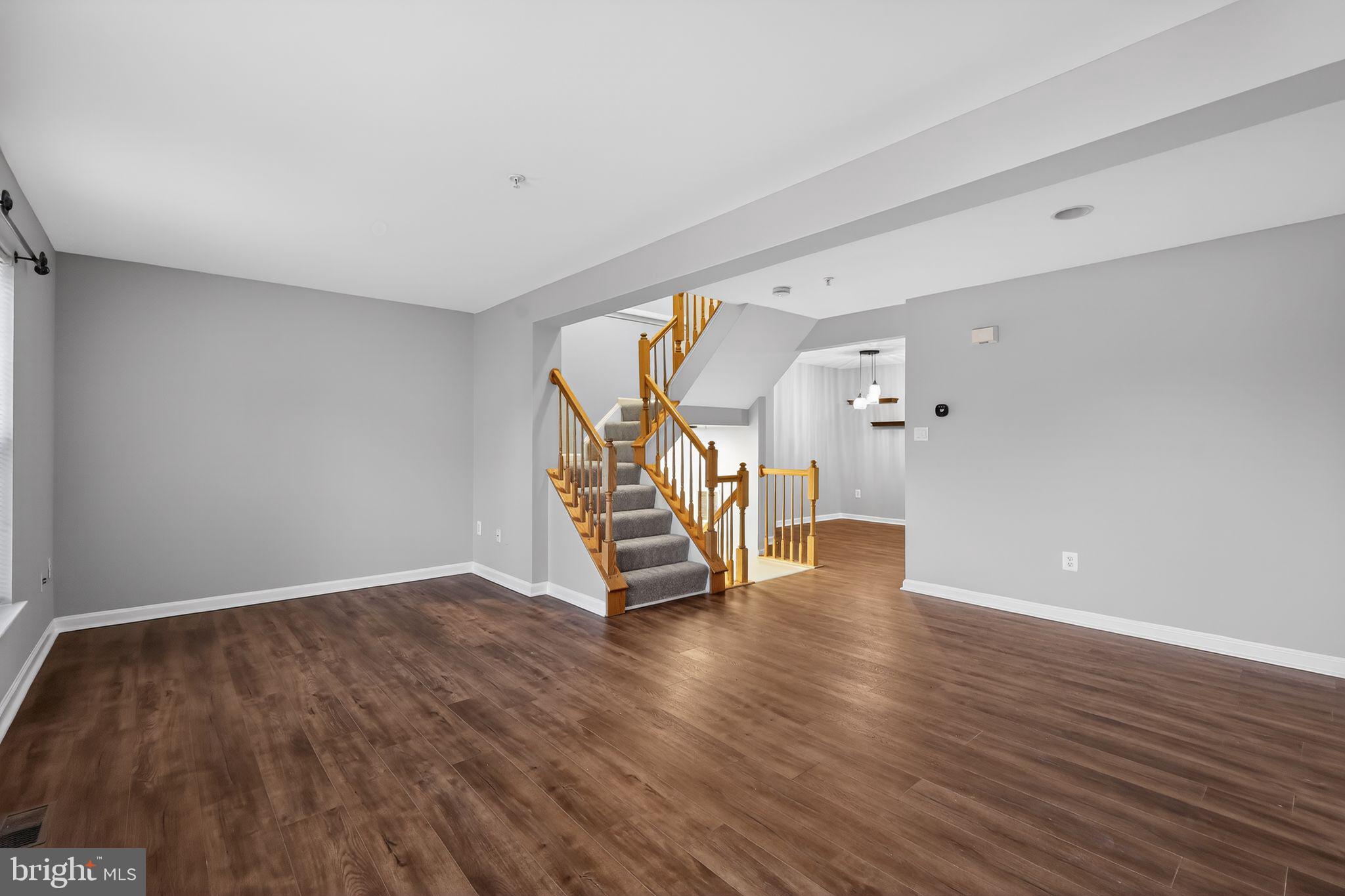 18707 Little Star Lane Germantown, MD 20874 - Photo 10 of 30 an empty room with wooden floor and staircase