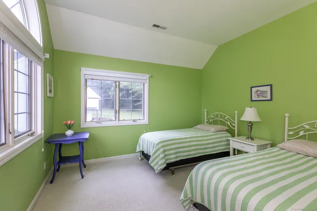 a bedroom with two beds chair and a window