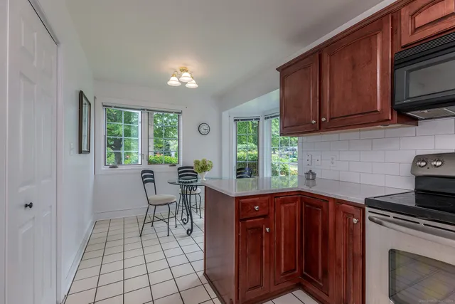 a kitchen with a sink a stove cabinets and wooden floor