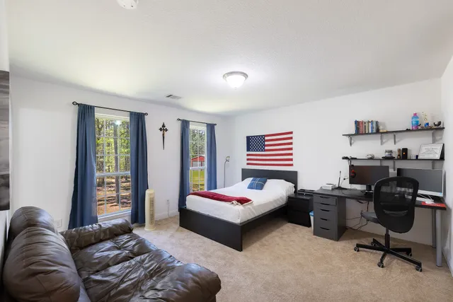 an empty room with windows and ceiling fan