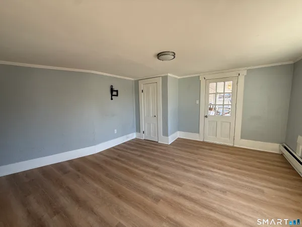 an empty room with wooden floor and windows