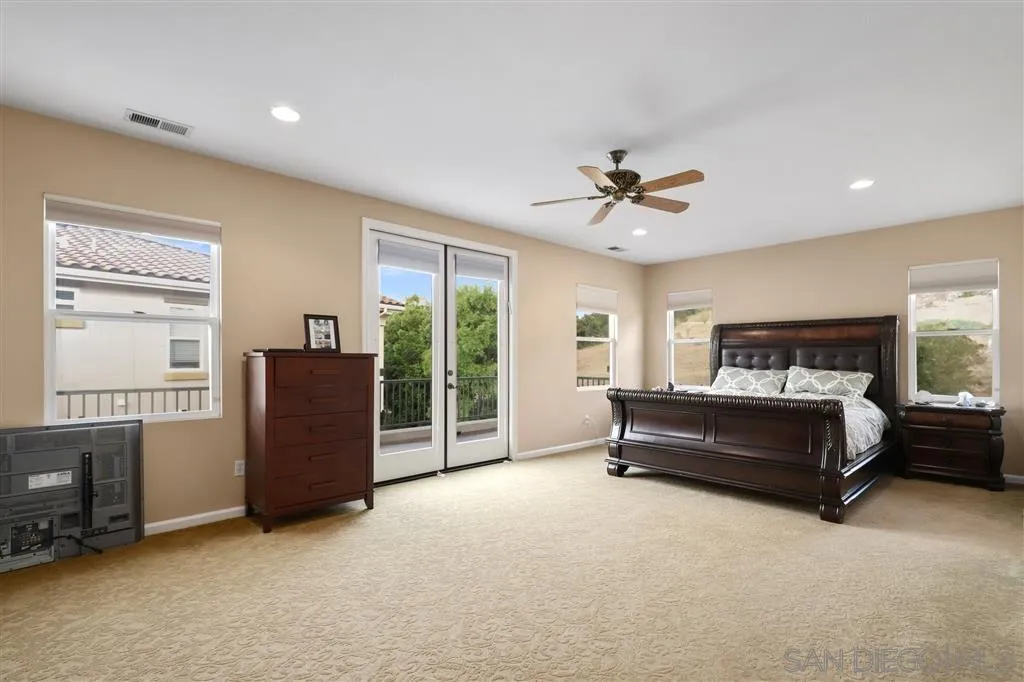 8403 Watson Ranch Road San Diego, CA 92129 - Photo 13 of 25 a spacious bedroom with a bed and a ceiling fan