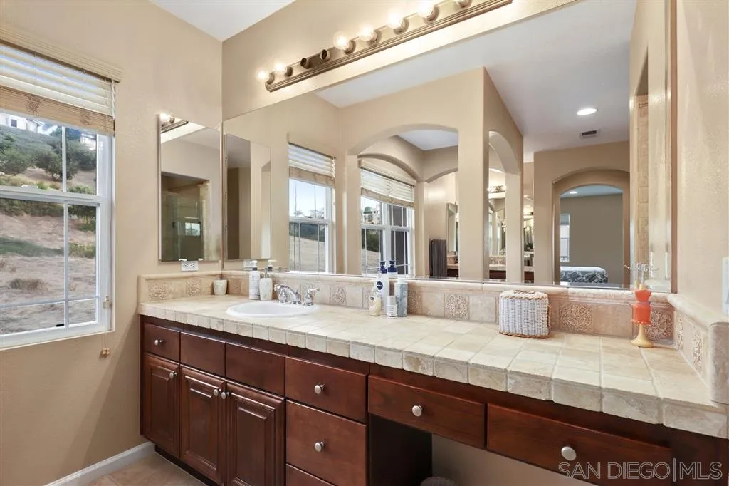 8403 Watson Ranch Road San Diego, CA 92129 - Photo 17 of 25 a bathroom with a granite countertop sink mirror and double