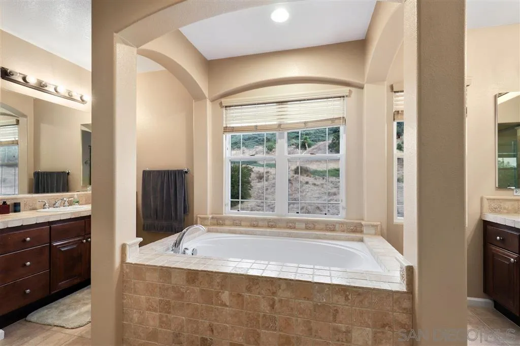 8403 Watson Ranch Road San Diego, CA 92129 - Photo 18 of 25 a spacious bathroom with a tub sink and mirror
