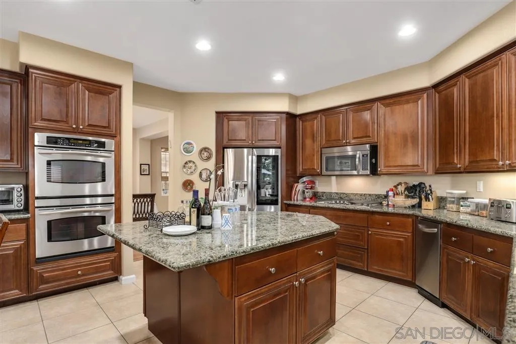 8403 Watson Ranch Road San Diego, CA 92129 - Photo 8 of 25 a kitchen with stainless steel appliances granite countertop a stove sink microwave and refrigerator