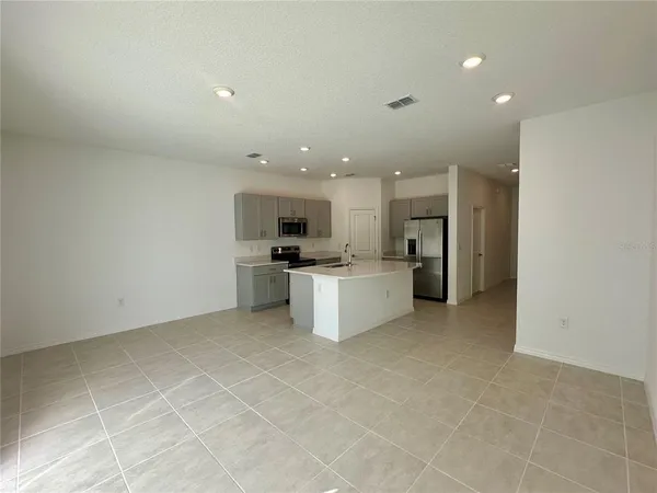 a kitchen with a refrigerator and white cabinets