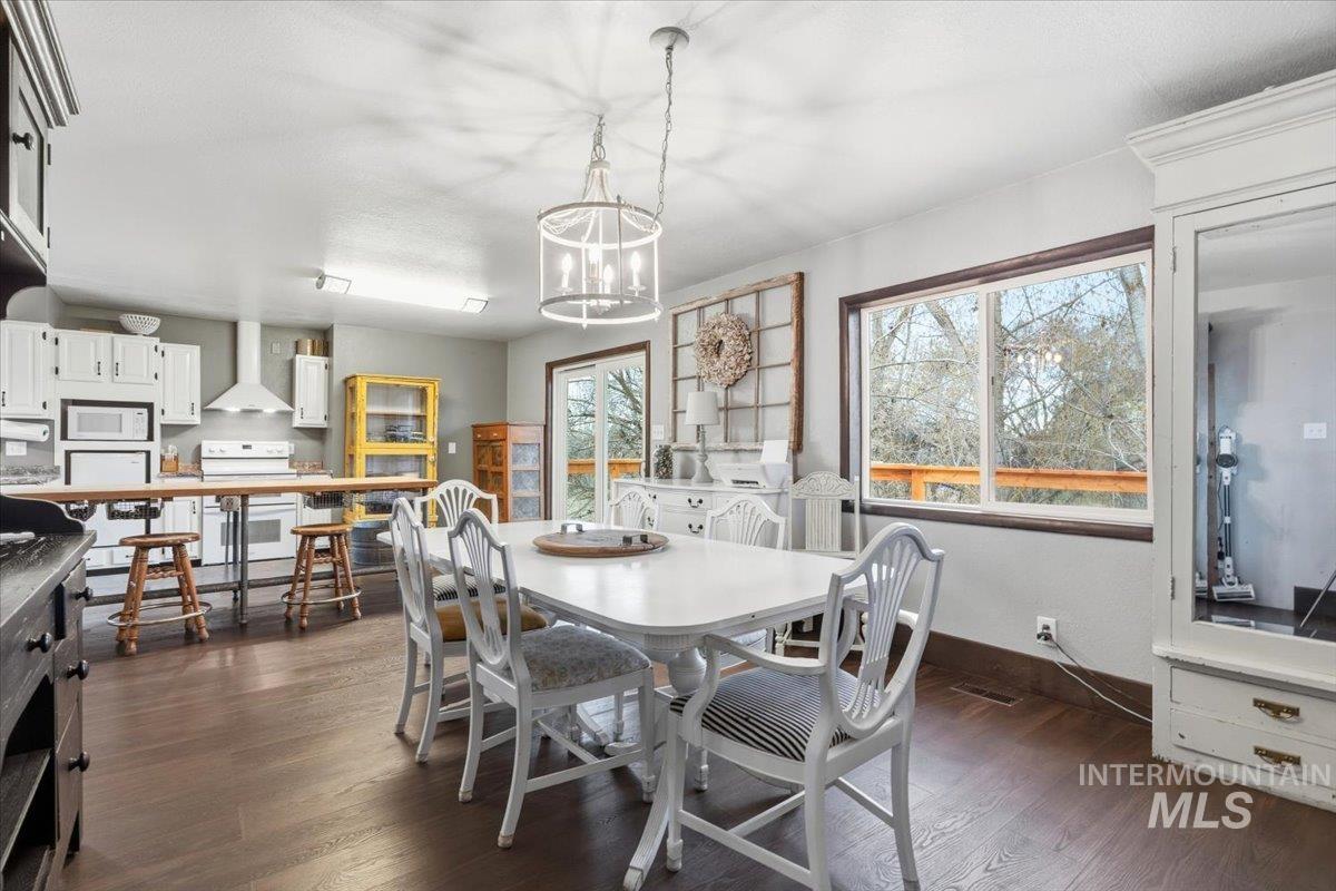 7771 Elmore Road Fruitland, ID 83619 - Photo 6 of 48 Dining area featuring dark wood-style floors and a chandelier