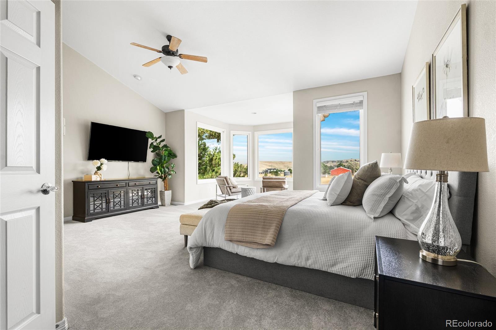 11041 Puma Run Lone Tree, CO 80124 - Photo 18 of 35 a spacious bedroom with a bed and a flat tv screen on dresser
