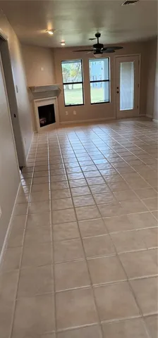 a view of an empty room with a fireplace and chandelier