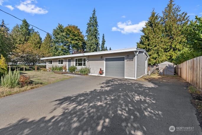 a front view of a house with a yard and trees