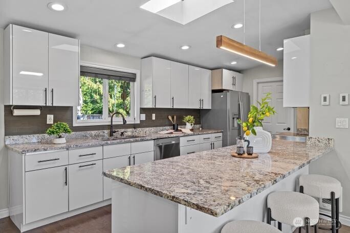 21904 88th Place West Edmonds, WA 98026 - Photo 10 of 40 a kitchen with kitchen island granite countertop a sink cabinets and window