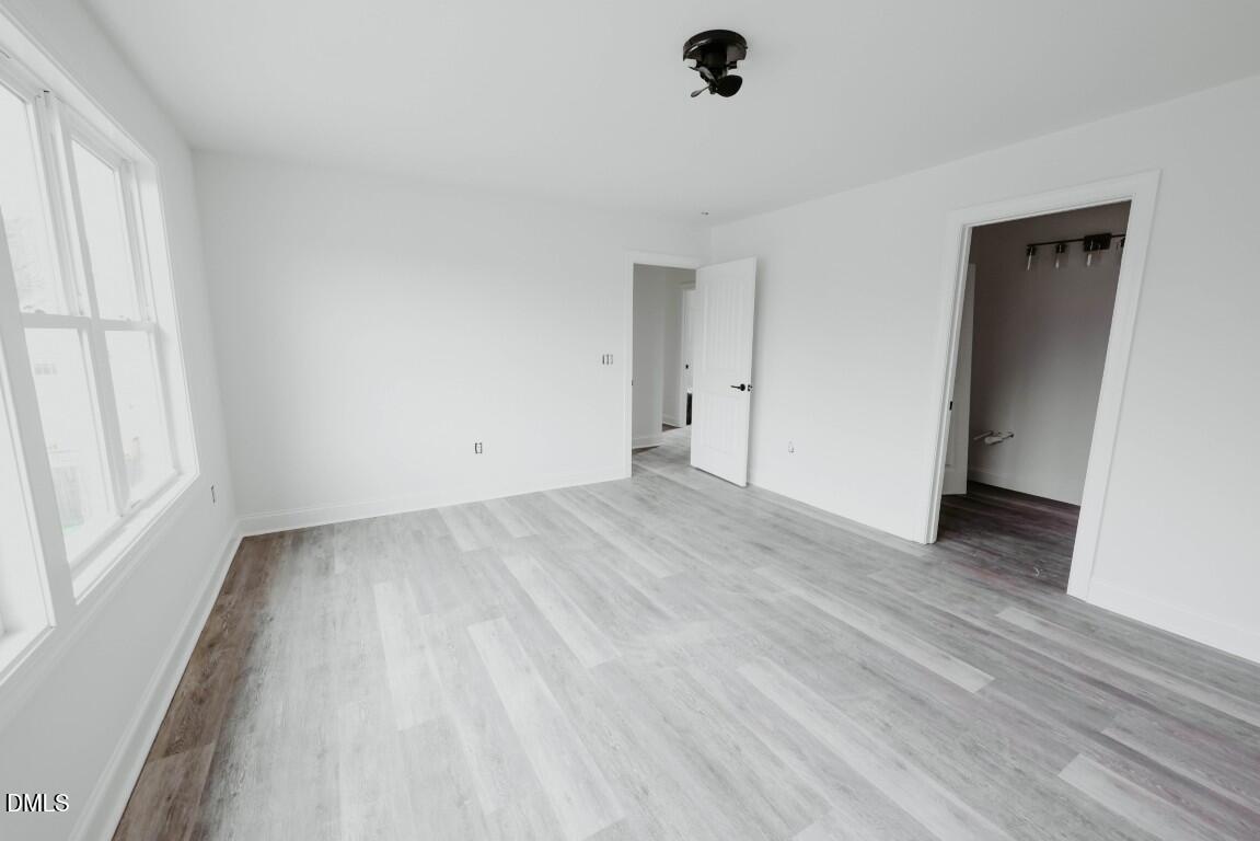 309 East Perry Avenue Wake Forest, NC 27587 - Photo 12 of 24 a view of an empty room with wooden floor and a window