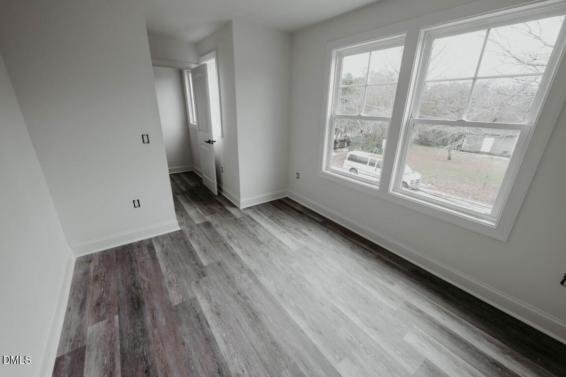 309 East Perry Avenue Wake Forest, NC 27587 - Photo 14 of 24 an empty room with wooden floor and windows