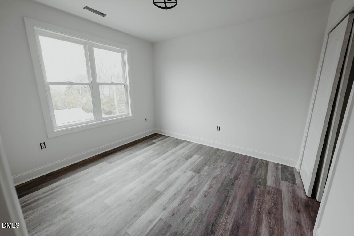 309 East Perry Avenue Wake Forest, NC 27587 - Photo 17 of 24 an empty room with wooden floor and windows