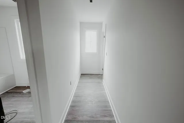 a view of a hallway with wooden floor