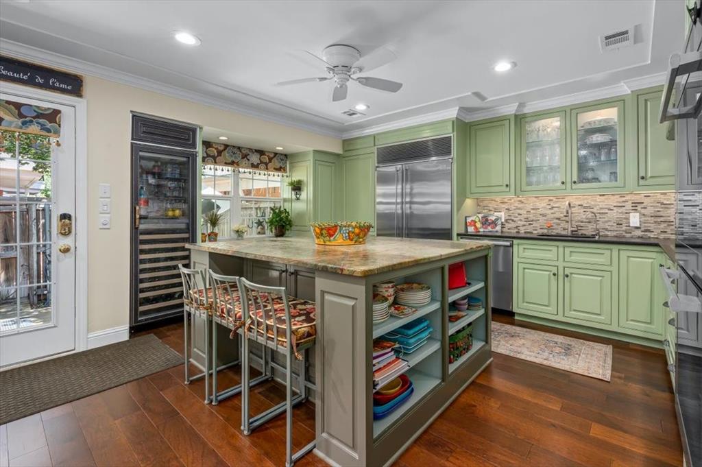 a kitchen that has a lot of cabinets in it and wooden floor