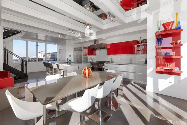 a view of a dining room with furniture a kitchen and chandelier