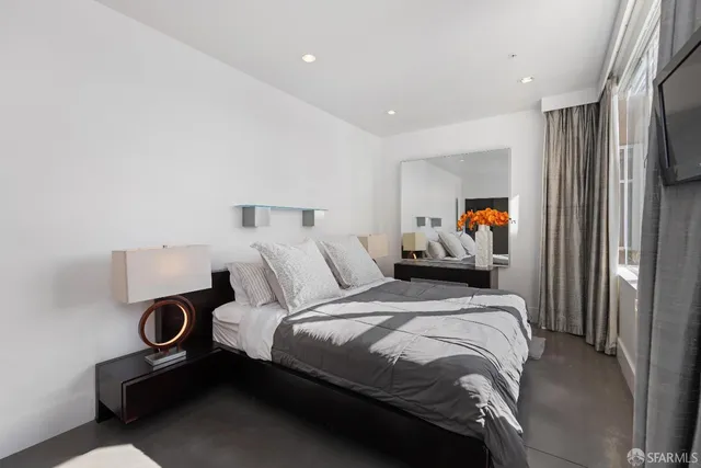 a bedroom with a bed and a refrigerator