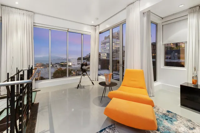 a living room with furniture and floor to ceiling windows