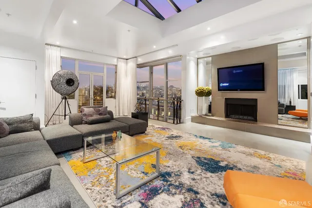 a living room with furniture a flat screen tv and a fireplace