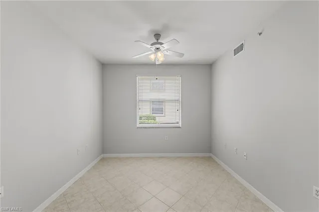 an empty room with a window and a ceiling fan