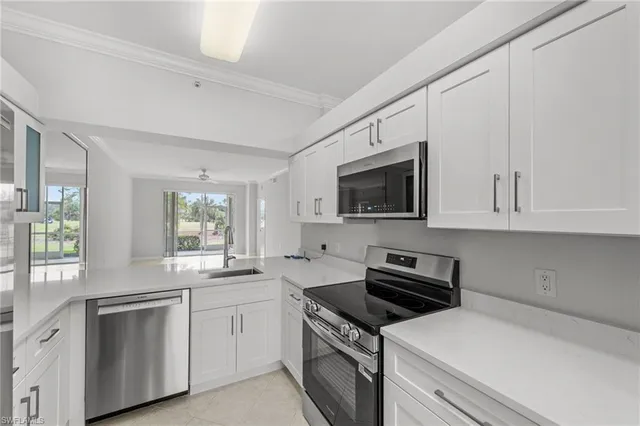a kitchen with white cabinets and appliances