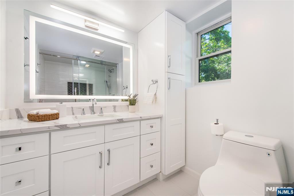 145 Grove Street Mahwah, NJ 07430 - Photo 24 of 30 a bathroom with a toilet a sink a vanity a window and mirror